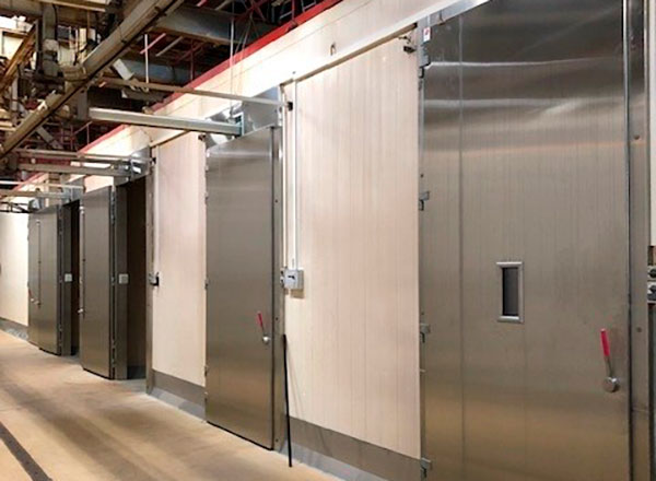 skyded&oslash;re i rustfri st&aring;l p&aring; slagteri med udsk&aelig;ringer til transportb&aring;nd