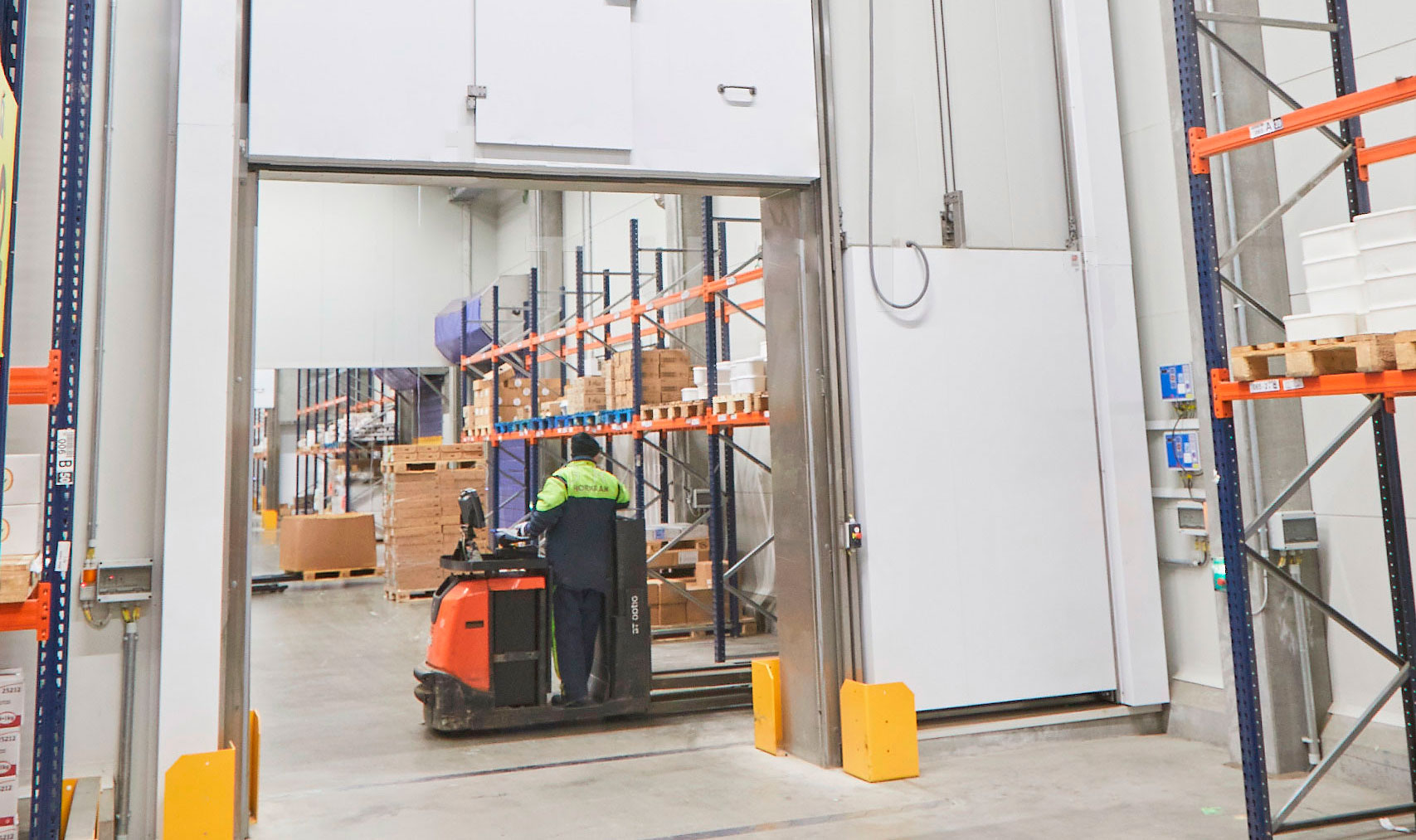 Medarbejder fragter varer p&aring; truck i k&oslash;lerum og ses under en vertikal brandskyded&oslash;r