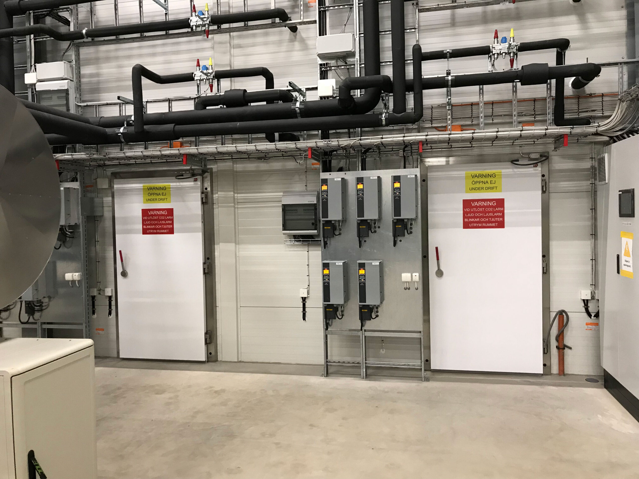 To sikkerhedsd&oslash;re med advarselsskilte til k&oslash;lerum  